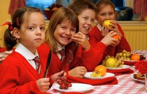 Some young children eating healthy lunches.