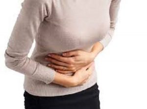 Person holding stomach with cramps.