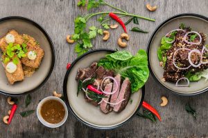Some meat plus salad on plates.