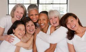 Middle-aged women laughing in a group.